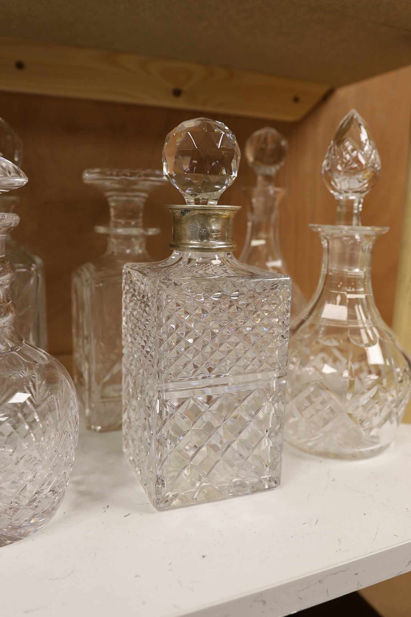 A silver mounted decanter, four others and a smaller pair of decanters, tallest 27.5cm